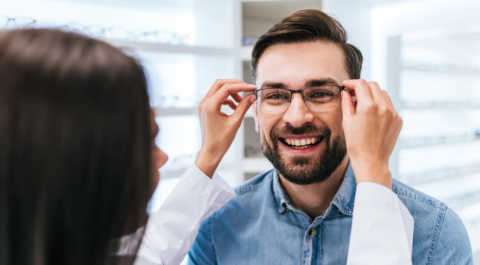 (image) opticienne plaçant sur le visage d'un particulier ses nouvelles lunettes